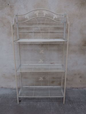 a white metal shelf with three shelves on it