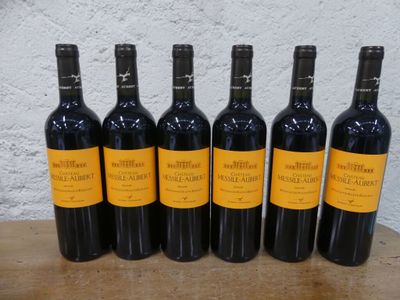 six bouteilles de vin sont alignées sur une table en bois