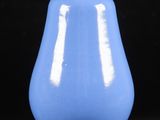 un vase bleu posé sur une surface noire