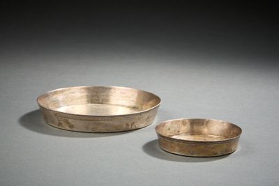 paire de bols en argent avec des anses et des bords sur une surface grise