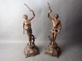 pair of antique bronze figurines of a woman holding a sword and a bird