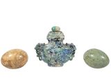 three stones and a vase sitting next to each other