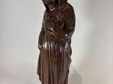 wooden statue of a woman holding a baby in her arms