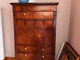 a dresser with a bowl on top of it in the corner of a room