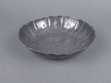 an antique silver plate with a flower design on the rim