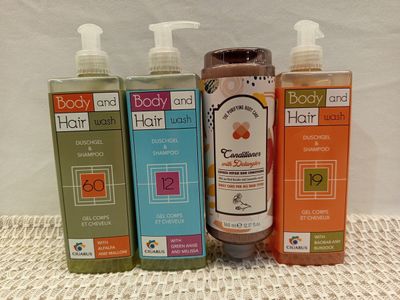 three bottles of body and body care products sitting on a table