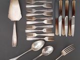 beaucoup d'argenterie sur une table avec des cuillères et des fourchettes