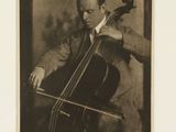 black and white photograph of a man playing a cello in a room