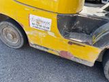 a yellow forklift truck parked on the side of the road