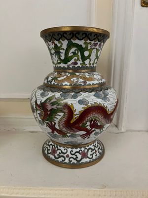 un vase orné d'un dragon, posé sur une étagère