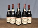 four bottles of wine are lined up on a wooden table