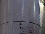 a large stack of white rolls of plastic in a warehouse