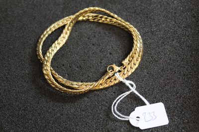Gros plan sur un bracelet en or portant une étiquette