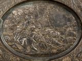a silver plate with a picture of a man riding a horse