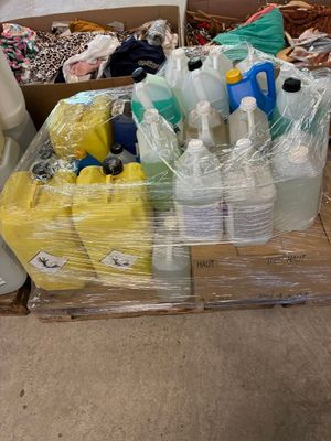 une boîte remplie de bouteilles en plastique et d'autres objets, posée par terre