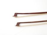 two pieces of wood are laying next to each other on a white surface