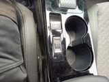 a close up of a car ' s center console with a cell phone in it