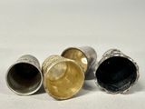 three silver and gold vases sitting on a white surface
