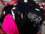 a suitcase full of clothes and a hat on the floor