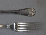 two forks and a spoon sitting on a table