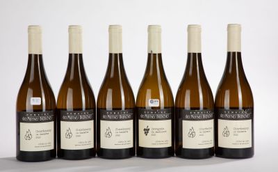 six bottles of wine are lined up in a row on a white surface