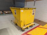 a yellow dumpster sitting in the middle of a warehouse