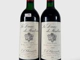 deux bouteilles de vin rouge posées l'une à côté de l'autre sur une surface blanche