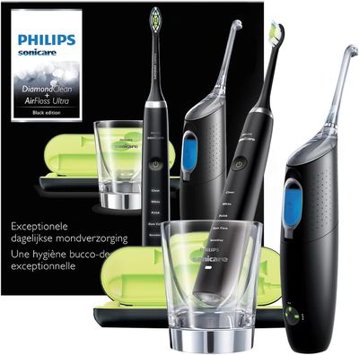 trois brosses à dents électriques et un verre posés devant une boîte