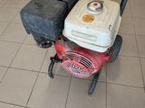 a red and white lawn mower sitting on a tiled floor