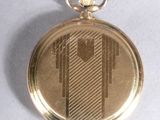 a gold pocket watch with a chain on a white surface