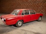 a red car that is parked in front of a brick wall