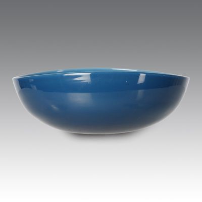 un bol bleu sur fond blanc, avec un fond gris