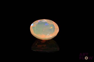 a white oplite stone on a black surface