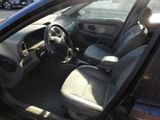 the interior of a car with the door open and the driver ' s seat down
