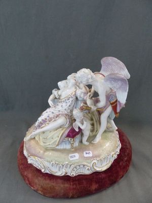 figurine en porcelaine représentant un couple assis sur un coussin rouge, tenant un parapluie