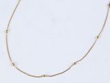 the gold beaded necklace is shown on a white background