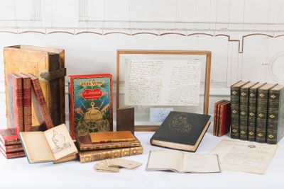 many old books on a table with a picture frame