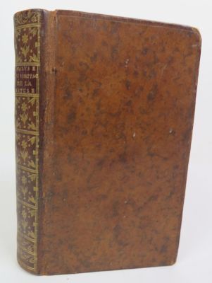 an old brown book sitting on top of a white surface