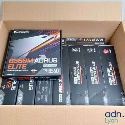Des cartons contenant du matériel de jeu varié sont empilés les uns sur les autres