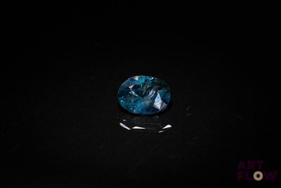 a close up of a blue sapphire stone on a black surface