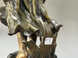 bronze statue of a woman holding a bird on a marble base
