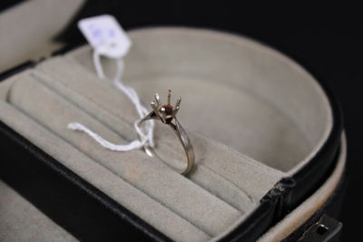 une bague dans un écrin à bague, avec une étiquette attachée