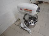 a white mixer sitting on the floor in a kitchen