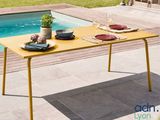a yellow table with plates on it next to a swimming pool