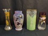 quatre vases de couleurs différentes posés les uns à côté des autres sur une table