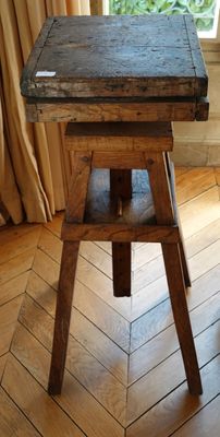 une petite table en bois avec un plateau en bois posée sur un plancher en bois