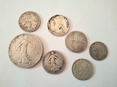 plusieurs pièces de monnaie sont disposées en cercle sur une surface blanche