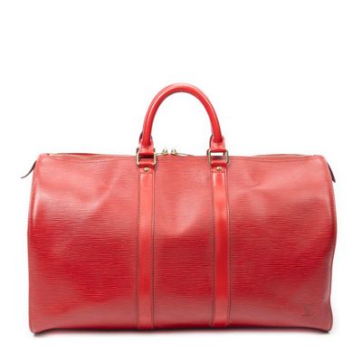 a red duffel bag sitting on top of a white surface