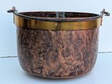 a large metal pot with a handle on a table