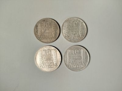 four silver coins sitting on top of a white surface